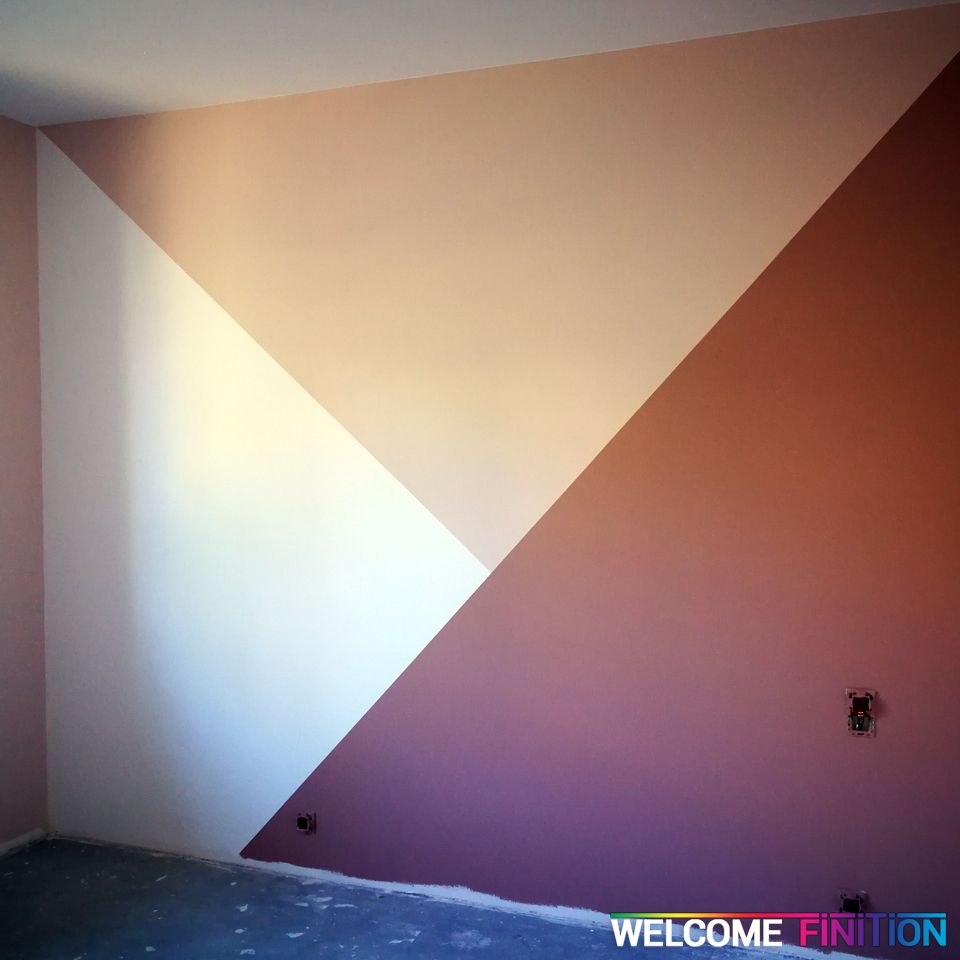 Mur peint en aplats géométriques dans une pièce de vie, réalisation Welcome Finition