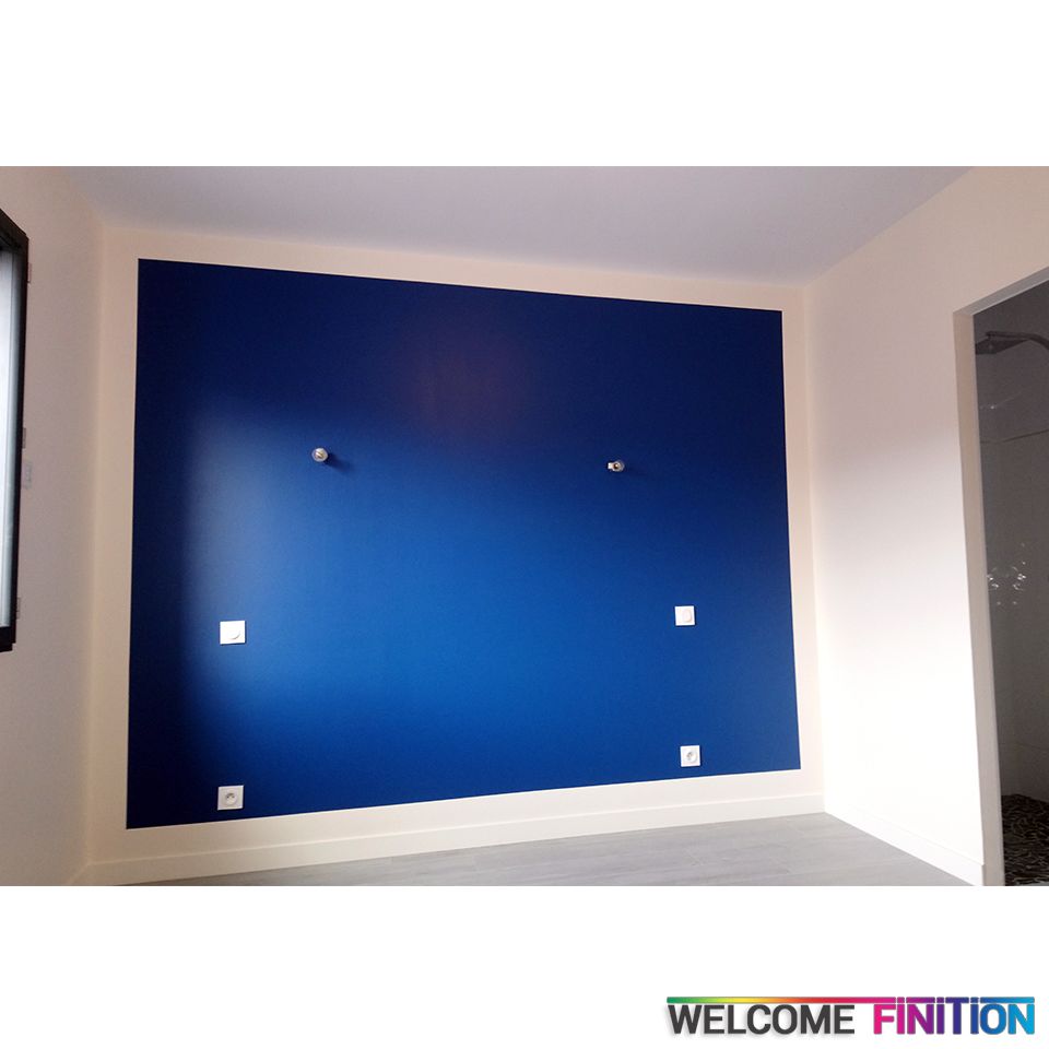 Mur peint en bleu profond encadré d'un liseré clair, réalisation Welcome Finition