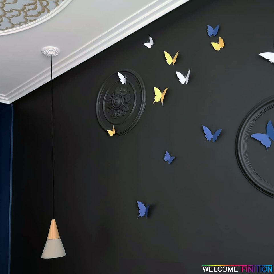 Rosace moulurée et papillons décoratifs sur un mur noir mat, réalisation Welcome Finition